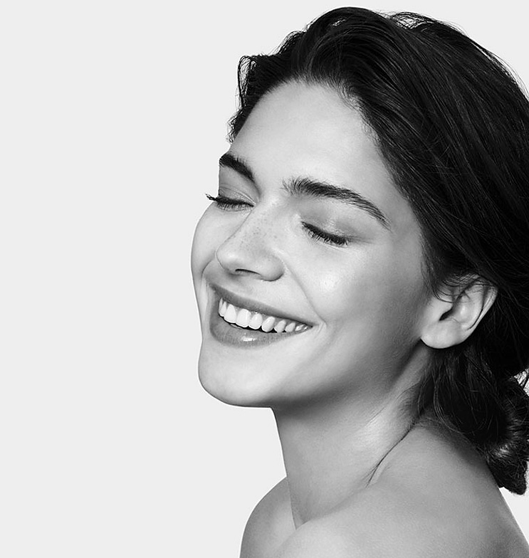 Frau mit strahlendem Lächeln und geschlossenen Augen